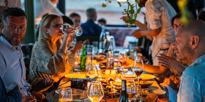 Gezellig gedekte tafel met gedeelde gerechten en wijnglazen bij San Thomas