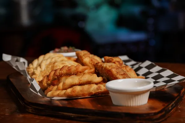 Tafel vol gedeelde Argentijnse gerechten met empanadas en salades
